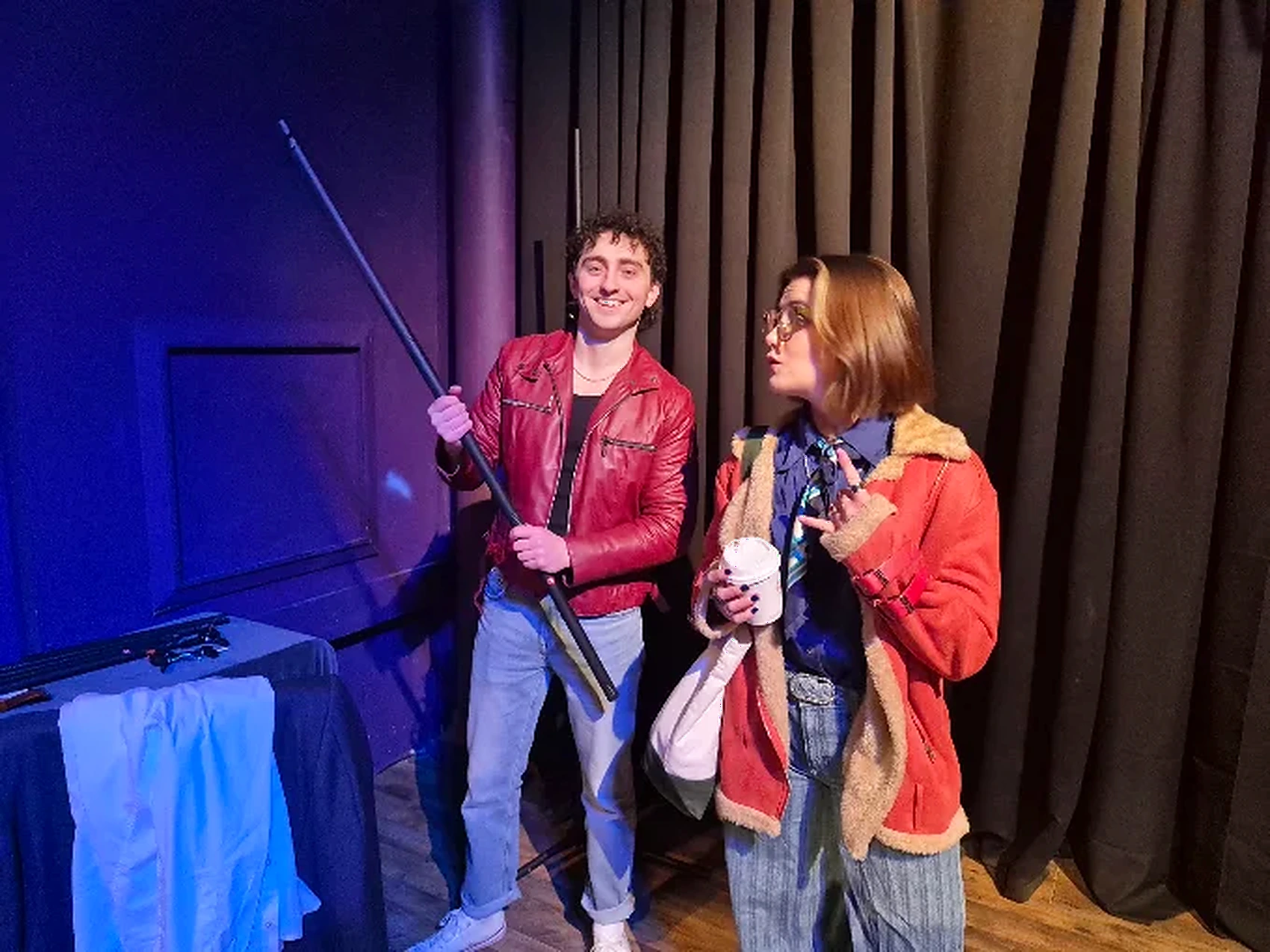 Actors performing a scene on a lit stage during a GreenRose production